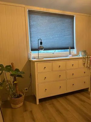 a bedroom with a dresser and a window with a sink at Sentral leilighet i Åsane in Sørebø