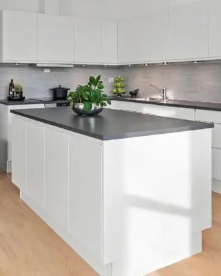 a white kitchen with a counter with a plant on it at Panoramic View & Comfort in Ålesund