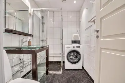 a bathroom with a washing machine and a washer at Heimby - Roomy Studio w Free parking and SeaView in Bergen