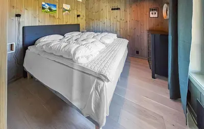 a large bed in a room with wooden walls at Stunning Apartment In Hemsedal in Hemsedal