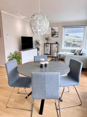 a living room with a dining room table and chairs at 2BR, 2 parking spots, EV-charger and home office in Trondheim