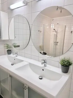 a bathroom with two sinks and a large mirror at 2BR, 2 parking spots, EV-charger and home office in Trondheim