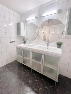 a bathroom with two sinks and two mirrors at 2BR, 2 parking spots, EV-charger and home office in Trondheim