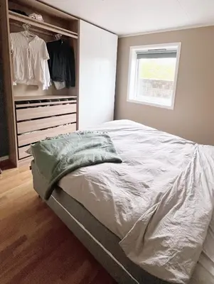 a bedroom with a bed and a closet at 2BR, 2 parking spots, EV-charger and home office in Trondheim