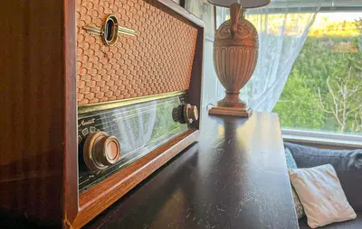 a table with an old radio on it next to a window at Awesome Home In Sævareid With Lake View in Sævareid