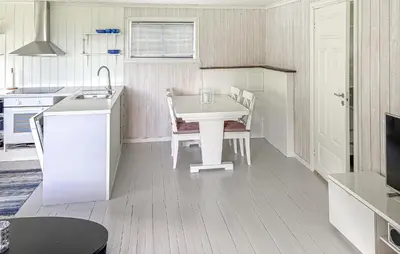 a white kitchen with a white table and chairs at 1 Bedroom Awesome Home In Vik I Sogn in Vikøyri