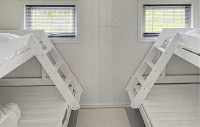 a bedroom with two bunk beds and two windows at 1 Bedroom Awesome Home In Vik I Sogn in Vikøyri