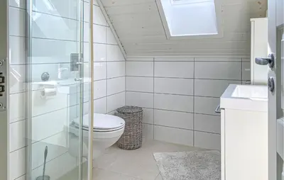 a bathroom with a toilet and a glass shower at 3 Bedroom Awesome Home In Gursken in Larsnes