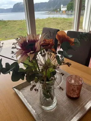 a vase with flowers in it on a table at Seljesanden Apartment in Selje