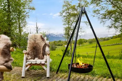 a chair and a fire pit in a field at Mountain Base For Active Explorers in Oppdal