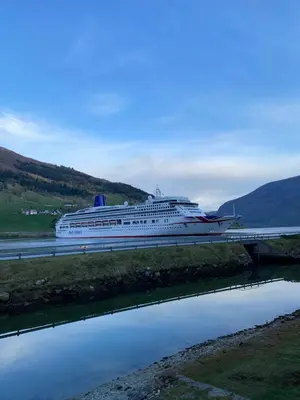a cruise ship docked in a river with a bridge at Sea Front Olden in Olden