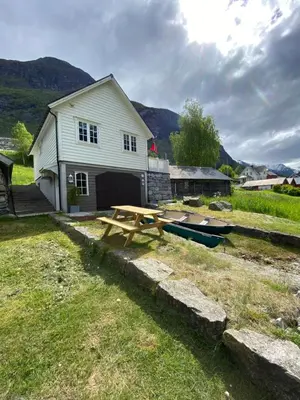 a picnic table in front of a house with a boat at Sea Front Olden in Olden