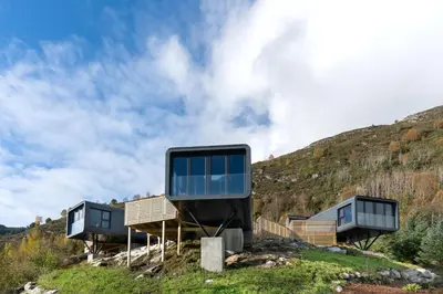 a house on a hill with a tv on it at Torvika Seaview Pods in Bølandet