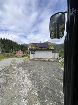 a view of a house with grass on the roof from a vehicle at Cozy chair in Jølster in Skei
