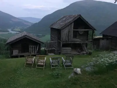 a group of chairs sitting in front of a house at Farm In The Heart Of Gudbrandsdalen in Kvam