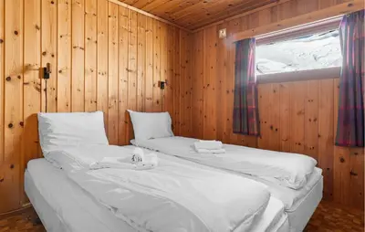 two beds in a wooden room with a window at Gorgeous Home In Vøringsfoss With Sauna in Maurset