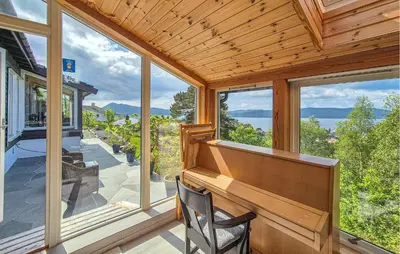 a porch with a piano and large windows at Nice Apartment In Bergen With Wifi in Bergen