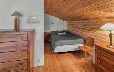 a bedroom with a bed and a wooden wall at Nice Apartment In Bergen With Wifi in Bergen