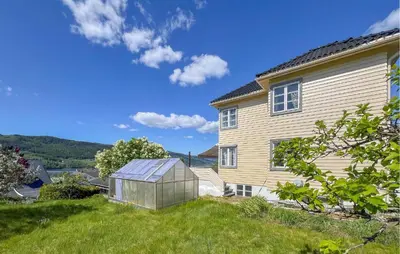 a greenhouse in a yard next to a house at Lovely Apartment In Lillehammer in Lillehammer