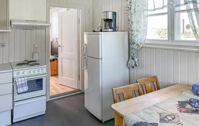 a kitchen with a white refrigerator and a table and a tableablish at 2 Bedroom Nice Apartment In Lillehammer in Lillehammer