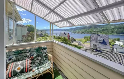 a balcony with a bench and a view of the water at 2 Bedroom Nice Apartment In Lillehammer in Lillehammer