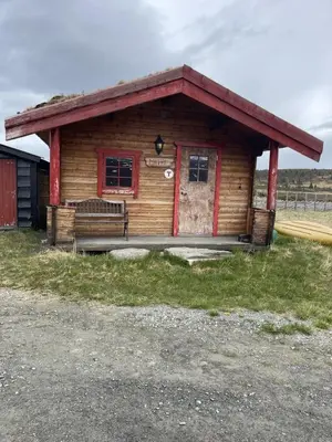 a small log cabin with a red door at Syndinstøga in Ryfoss