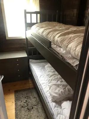 two bunk beds in a room with a window at Syndinstøga in Ryfoss