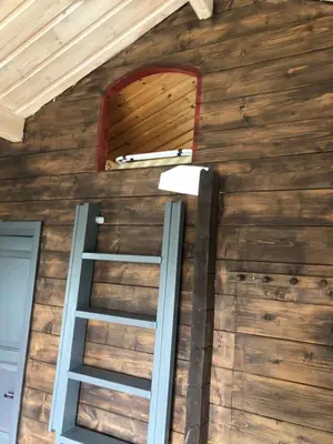 a room with a wooden wall with a ladder at Syndinstøga in Ryfoss