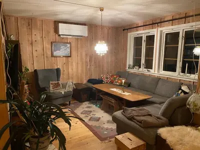 a living room with a couch and a table at Huset Utsikten på Langsjøvolden gård in Tolga