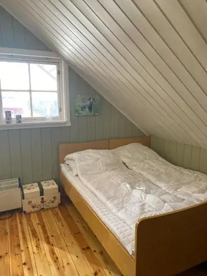 a bed in a room with a roof at Huset Utsikten på Langsjøvolden gård in Tolga