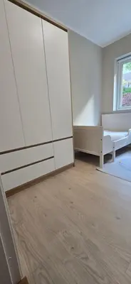a bedroom with white cabinets and a bed and a window at Modern house in Bergen