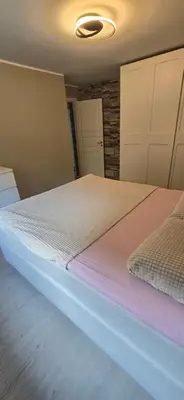 a bedroom with a large bed with white sheets at Modern house in Bergen