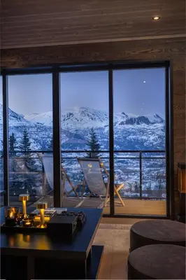 a living room with a view of snow covered mountains at New and exclusive chalet apartment with mountain panorama view in Tuv
