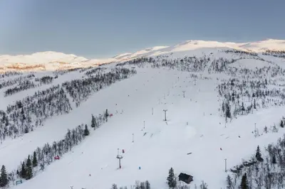 a snow covered ski slope with people skiing on it at New and exclusive chalet apartment with mountain panorama view in Tuv