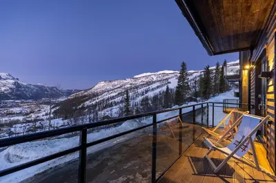 a balcony with two chairs and a view of the mountains at New and exclusive chalet apartment with mountain panorama view in Tuv