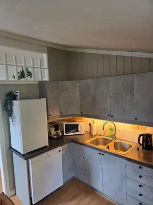 a kitchen with a white refrigerator and a sink at Hardanger Fjord Living in Vossevangen