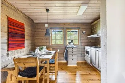 a kitchen with a table and chairs in a room at Guest favorite - 5 mins from Vøringsfossen in Garden