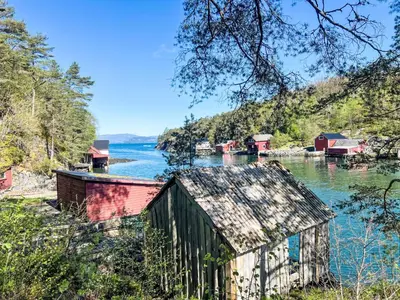 a river with a bunch of buildings in the water at Holiday Home Tussebu by Interhome in Gripne