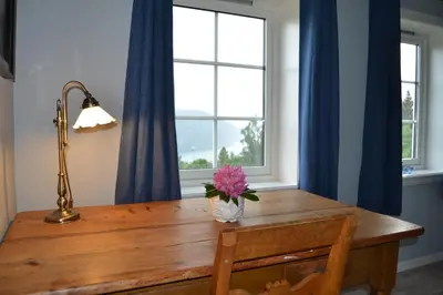 a dining room table with a vase of flowers on it at Charming farmhouse with jacuzzi and patio in Stryn