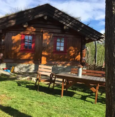 a log cabin with a picnic table and a bench at Holiday cabin, Kristianplass at Bjorli, Lesja in Bjorli