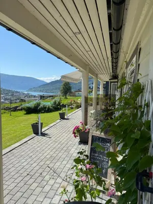 a porch of a house with a sign and flowers at Stryn Central View in Stryn