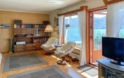 a living room with two chairs in front of a window at Stunning Apartment In Selje With Wifi in Selje