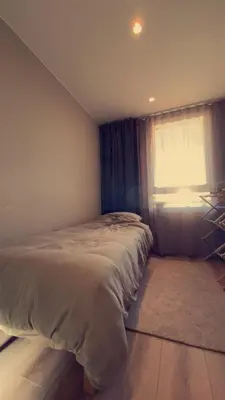 a bedroom with a bed with a window and a rug at Penthouse apartment with sauna, balcony and free coffe in Bergen