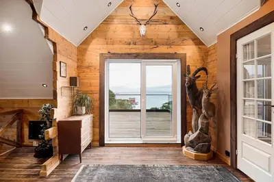 a room with wooden walls and a door with a window at Kvitsand Ocean Castle in Hitra