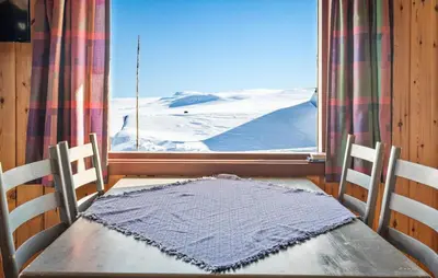 a table and two chairs in front of a window at Awesome Home In Vøringsfoss With Sauna in Maurset