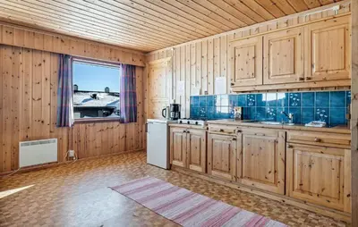a kitchen with wooden cabinets and a sink and a window at Awesome Home In Vøringsfoss With Sauna in Maurset