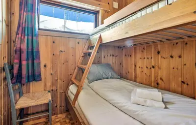a bunk bed in a wooden cabin with a ladder at Awesome Home In Vøringsfoss With Sauna in Maurset