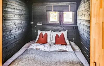 a bedroom with a bed with two red pillows at Lovely Home In Vøringsfoss With Sauna in Maurset
