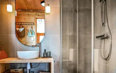 a bathroom with a sink and a shower with a mirror at Lovely Home In Vøringsfoss With Sauna in Maurset