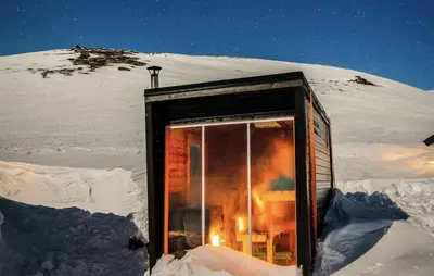 a small cabin in the snow with a window at Lovely Home In Vøringsfoss With Sauna in Maurset